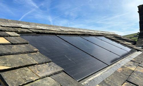 Image of a stone roof with in set solar panels.