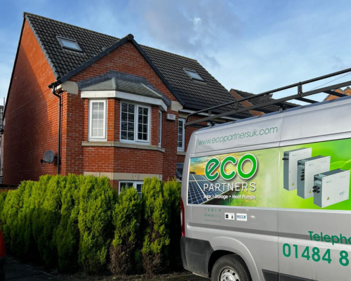 An image of a red brick house with an Eco Partners van parked in front.