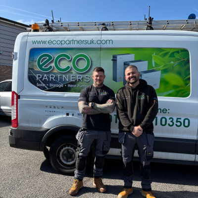 Image of 2 Eco Partners members of staff with a White Eco Partners sign written van behind them in the background.