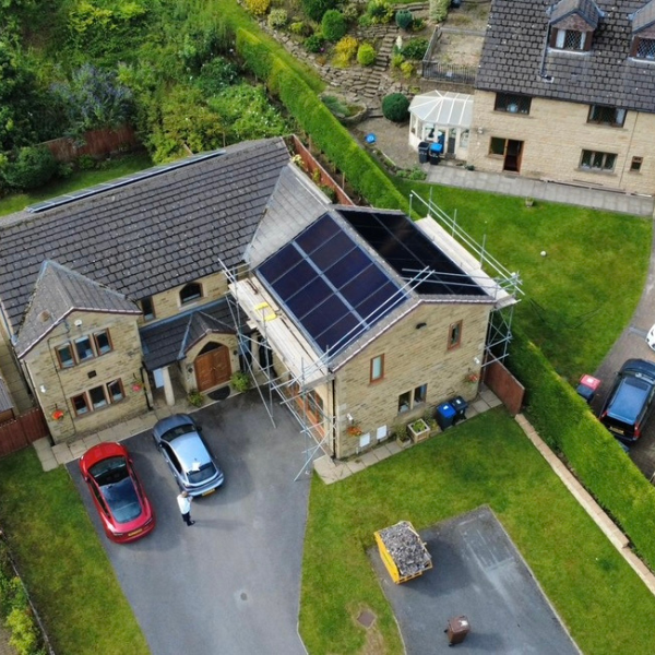 An Image of a Detached house with solar PV panels on the roof, fitted by Eco Partners Bradford.