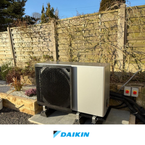 Daikin air source heat pump installed beside a garden wall